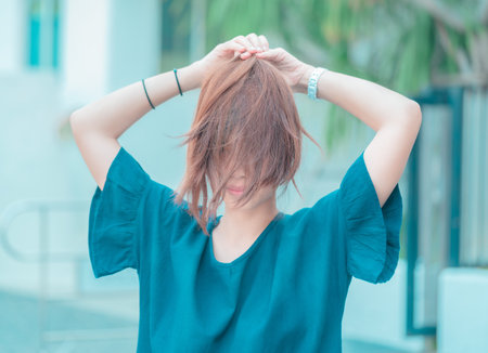 Asian woman with messy hair tight up looking fun and joyful with smile. For carefree woman concept.