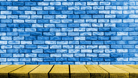 Yellow Wooden display board shelf table counter with copy space for advertising backdrop and background with Blue brick wall background.の写真素材