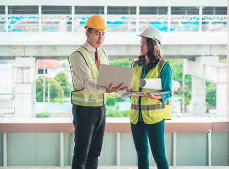 two engineer male and female is discussing on document plant with City infrastructure in the background.の写真素材