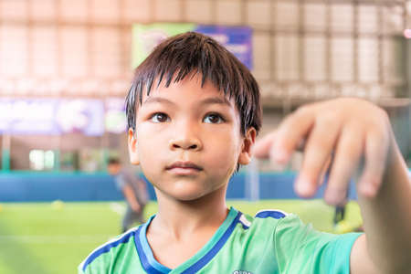 Portrait of an asian boy in Soccer uniform in an indoor soccer training pitch.の写真素材
