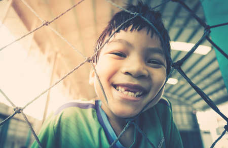 Happy asian kid with smile in a soccer training field for children sport recreation lifestyle concept.の写真素材
