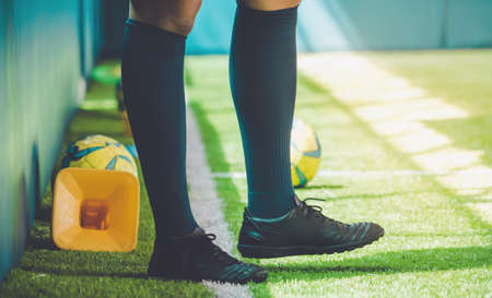 Men with soccer boots and legs standing on football training ground.の写真素材