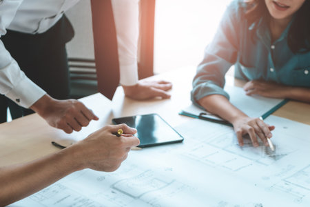 Construction team engineer and architect is brainstorming on working table with building plan