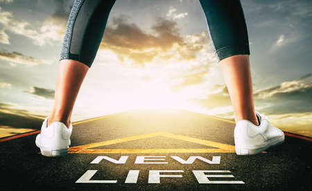 Woman standing on New life road leading to golden sky for New begining concept.の写真素材