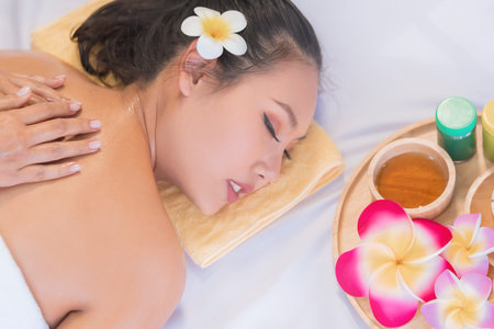 Closed up hand doing aroma oil massage on a beautiful woman back in Thai Spa aromatherapyの写真素材