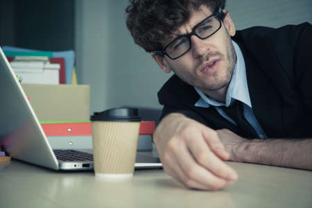 Hopeless business man resting on the office desk with frustation emotion and exhausted face.の写真素材