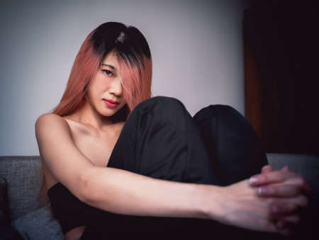 Sporty Asian woman is posing cool on sofa with seductive active black clothing for Street Girl fashion style.の写真素材