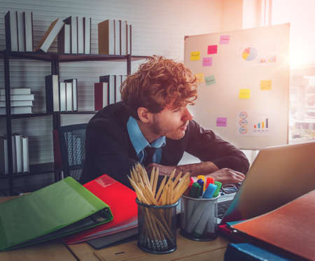 Business man waking up in the morning at his office after a long night overtime working with sunlight from the windows.の写真素材