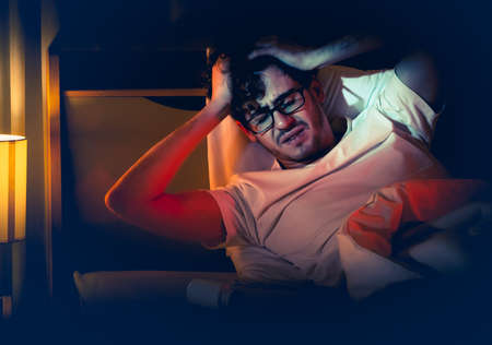 tired caucasian male having stressed problem with sleeping pill medication for insomnia treatment.の写真素材