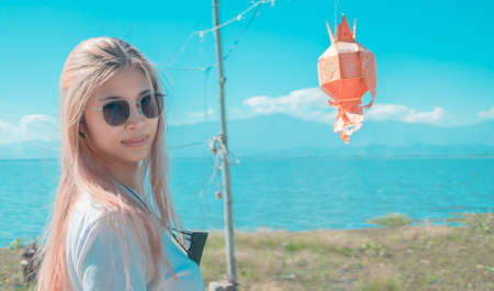 Asian woman took protection mask off and enjoy freedom from epidemic over in Nature with worry free and relaxation.の写真素材