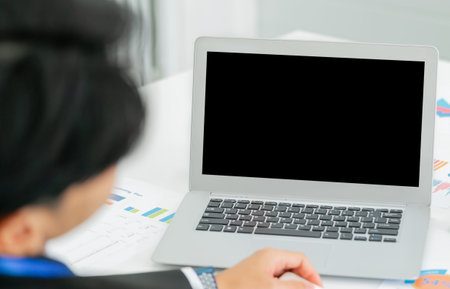 Asian Businessman sitting in front a blank screen laptop computer for mock up and template.