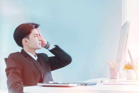 Young Businessman is exhausted and frustated after a long hour of work in office.の写真素材