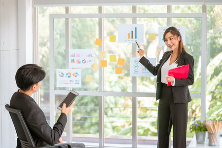 Business team is presenting on a glass board in a business team marketing meeting.