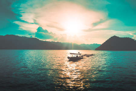 Ship traveling in open water with mountain island in the background.の写真素材