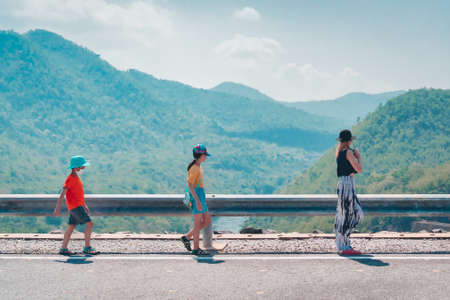 Children playing on the road at Mae Fah Luang Dam in Chiang Rai, Thailand.の写真素材