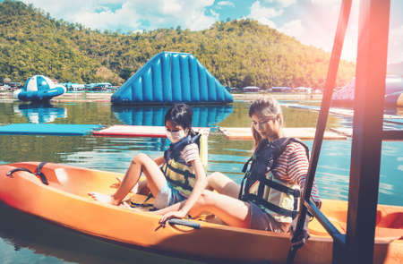 Mother and child is getting off on a Canoe boat in a nature lake.の写真素材