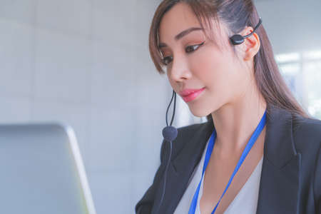 Asian Operator, Customer service assitance is answering call from client over internet computer call.の写真素材