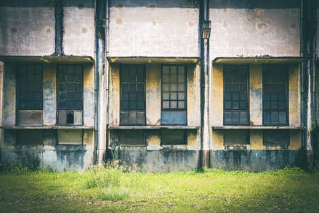 Windows of an old rustic abandoned factory, industry building frony view.の写真素材
