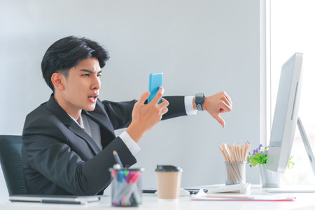 Businessman showing thumb down gesture for negative rejection while talking on the phone.の写真素材
