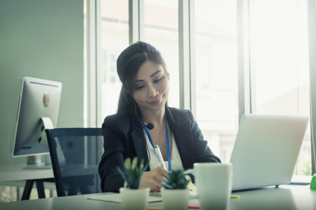 Asian. Female Operator is answering the phone for customer service sale and business consultant.