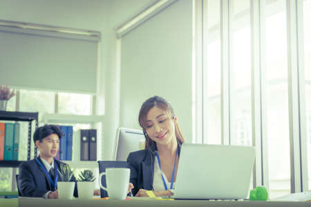 Asian. Female Operator is answering the phone for customer service sale and business consultant in a support office.の写真素材