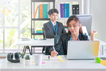 Asian. Female Operator is answering the phone for customer service sale and business consultant in a support office.の写真素材