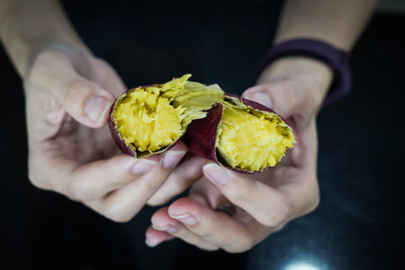 Asian woman is peeling Sweet Potatoes, closed up shot.の写真素材