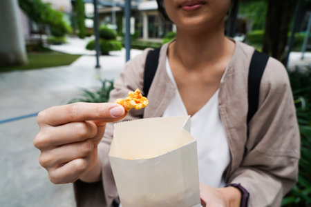 Woman holding popcorn cheese in a paper bag  in the handの写真素材