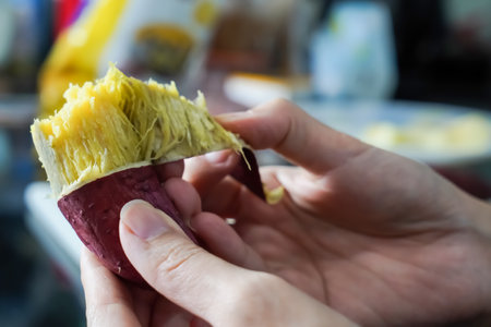 Asian woman is peeling Sweet Potatoes, closed up shot.の写真素材