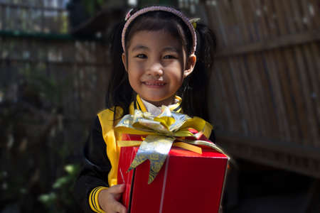 A little girl holding a gift.の写真素材