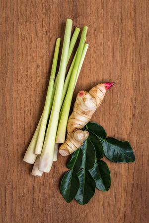 Thai herb lemongrass,galanga and kaffir lime leaf for some Thai soup call TOM YUM on the wooden background.の写真素材