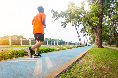 Motion blured, Back view of young sport man runner warm up before running, Background against sunrise morning.の写真素材