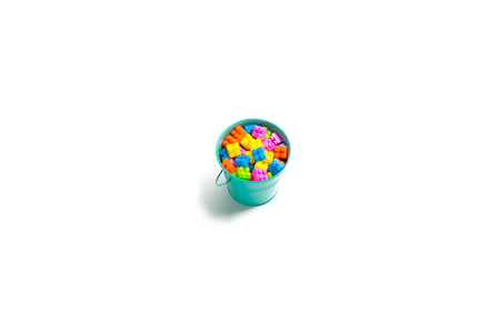 Plastic Building blocks - plastic construction in bucket colorful children's toy isolated on white backgroundの写真素材