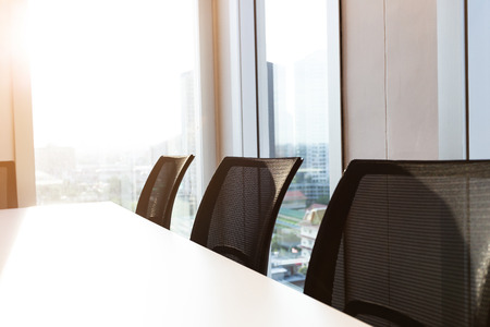 Row office chair in modern meeting room executive office with large windows, black office chair, outside building, city, tower view, soft focus.の写真素材