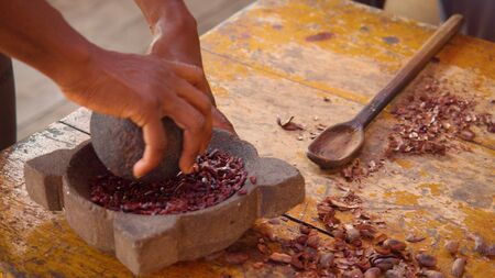 Detail Shot Of Hands Grinding Cocoa Beans With A Mortar In Ecuadorの写真素材