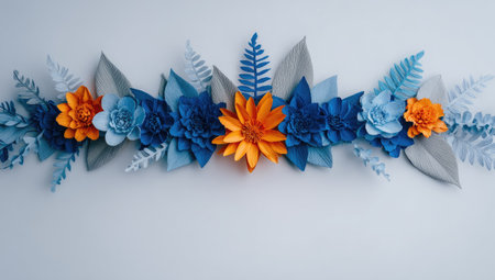 Vibrant paper floral arrangement with shades of blue, orange, gray, and white on a light backgroundの素材