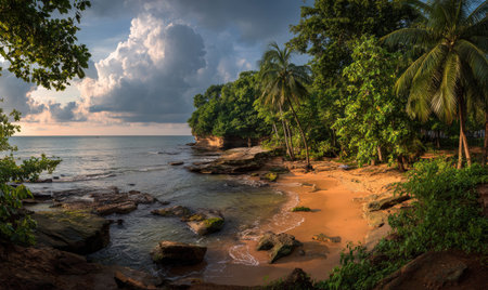 Tropical coastline with beach, rocks, palm trees, lush vegetation, and cloudy skyの素材