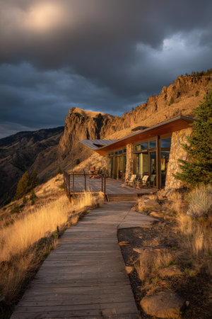 Modern dwelling perched on cliffside, wooden walkway, dusk lighting, dramatic skyの素材