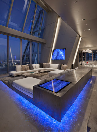 The interior features a modern living room, showcasing a large sectional sofa and integrated blue lighting. A large window offers an urban view, while the design incorporates sleek lines and minimalist decor. This versatile setting can be used for commercial projects related to interior design and architectural themes.の素材