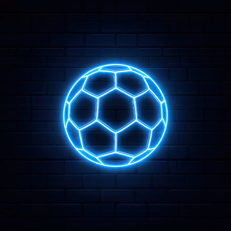 A neon blue soccer ball is depicted with a glowing outline, set against a dark brick wall backdrop. The graphic showcases a geometric pattern and highlights the ball's shape. The composition utilizes minimalist design with a vibrant color palette suitable for various commercial and creative projects.の素材