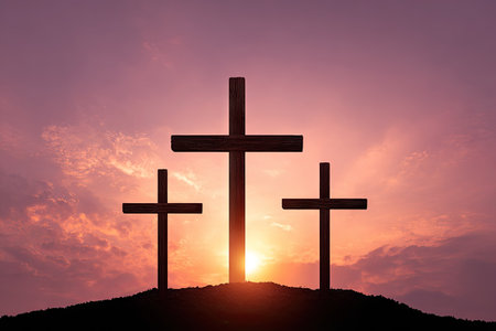 Three dark crosses stand silhouetted against a vibrant sunset sky. The composition features the crosses atop a hill. The scene evokes a sense of spirituality and hope, lit by the warm hues of the setting sun. Suitable for use in religious publications, presentations, or related design projects.の素材