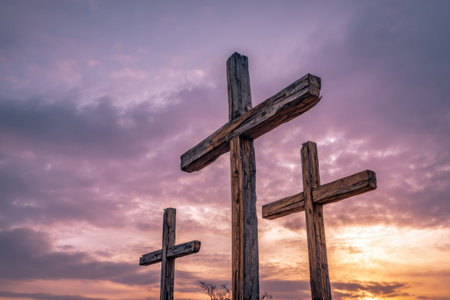 The image features three aged wooden crosses silhouetted against a vibrant sunset. The composition highlights the crosses' textures and shapes, with hues of purple, orange, and yellow illuminating the scene. This could be used for various projects, including religious themes, symbolic representation, or creative concepts.の素材
