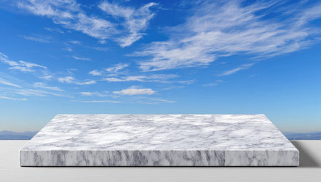 A rectangular marble surface is presented against a bright blue sky filled with wispy white clouds. The composition features a clean, neutral style with ample copy space and soft lighting. This image is suitable for various commercial applications, including product displays or background elements.の素材