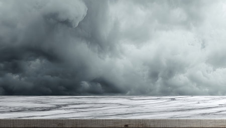 A gray, cloudy sky dominates the background, creating a moody atmosphere. A marble surface provides a foreground, its texture visible under the diffused light. The composition offers copy space, suitable for product showcases, advertising campaigns, or editorial content. The image evokes a sense of anticipation and potential.の素材