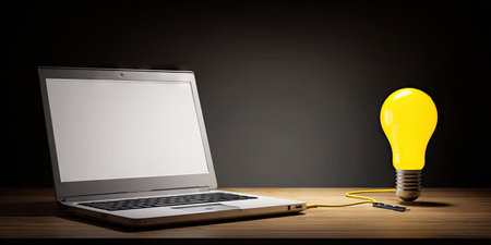 A laptop sits beside a brightly glowing lightbulb, connected by a wire, on a wooden surface. The scene features a dark backdrop, and soft lighting illuminates the subjects. The composition suggests concepts of technology, ideas, and innovation, suitable for various commercial and editorial purposes.の素材