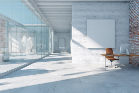The image depicts a contemporary office space bathed in natural light. A large glass wall and a high ceiling contribute to the open feel. The composition showcases a desk, a computer, and several blank artworks on the walls. The clean design and bright environment are suitable for various uses.の素材