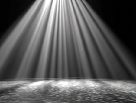 Bright, parallel light rays descend upon a rough, reflective surface. The composition features high contrast, emphasizing the play of light and shadow. The abstract visual elements create a sense of depth and focus. This image could be suitable for various creative projects and promotional content.の素材