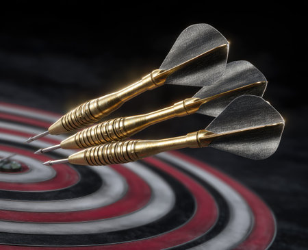 Three darts rest upon a target board. The composition features a close-up view with focus on the darts' metallic tips and feathered tails against a red and white concentric circle background. The lighting creates strong contrasts, highlighting textures. Suitable for conceptual themes, such as accuracy or sport.の素材