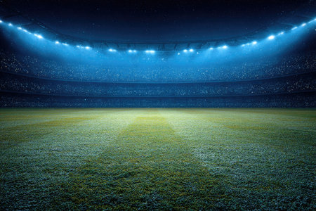 An illuminated stadium showcases a lush green field under brilliant spotlights. The image displays a wide, open view of the arena, with a blue-toned atmosphere. The composition suggests a sense of scale and anticipation. Suitable for sports, events, and commercial applications, this image offers versatile use.の素材