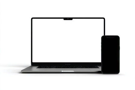 A laptop computer and a smartphone are presented against a clean white backdrop. The devices exhibit a minimalist aesthetic, emphasizing their sleek design. The composition uses studio lighting to showcase the subjects. This image is suitable for projects relating to technology, communication, or business themes, and can be employed in various promotional materials.の素材